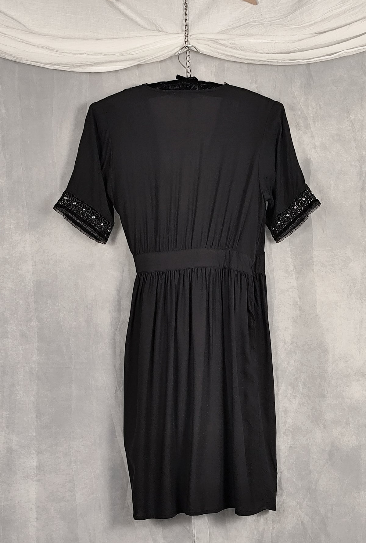 Back of ana alternative black wrap dress with studs, velvet and tulle details.