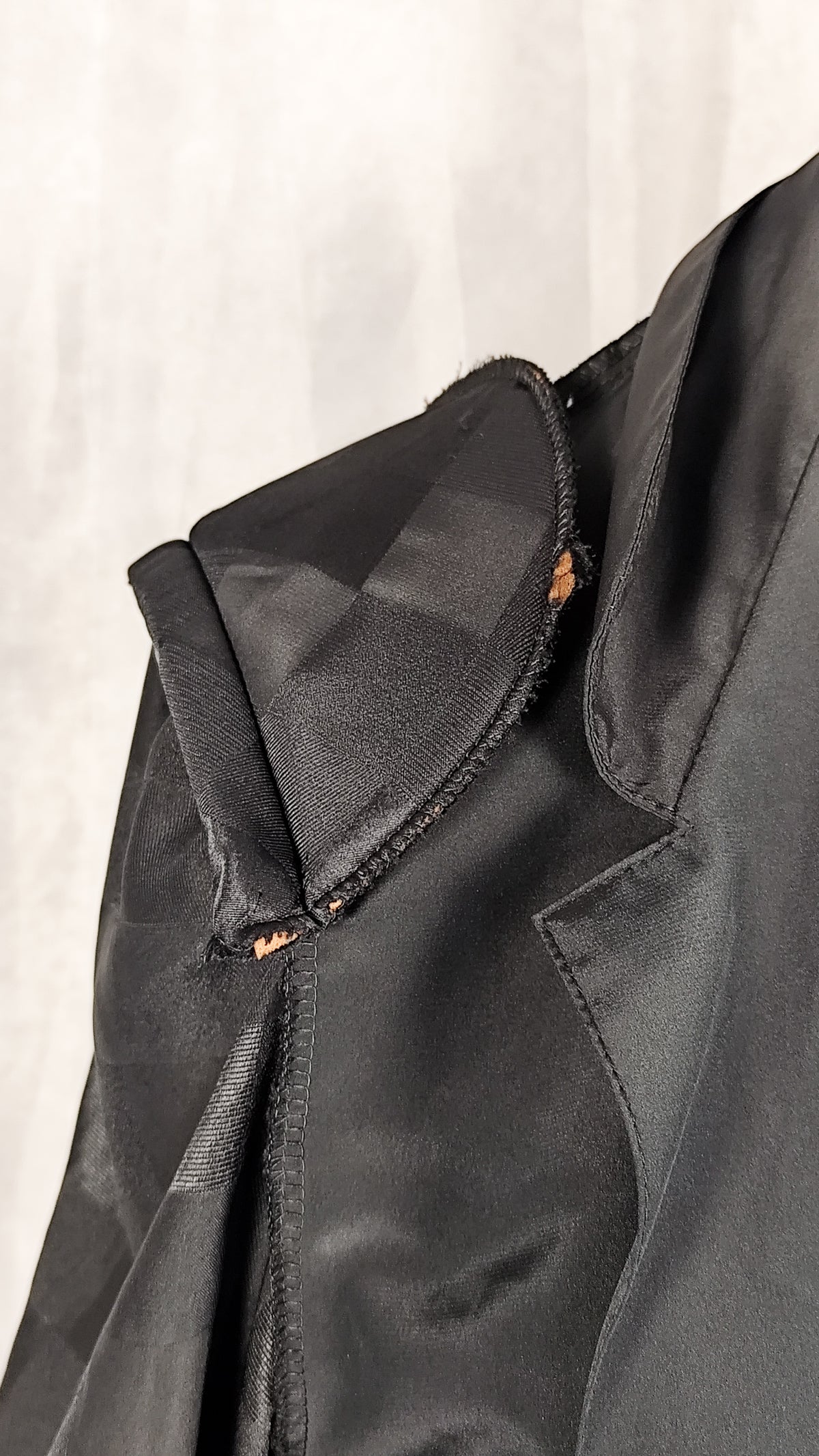 Close up of a shoulder pad of a black patterned sheer blouse from the 90's with a checkered design, for sale at Faceless Queen store. 