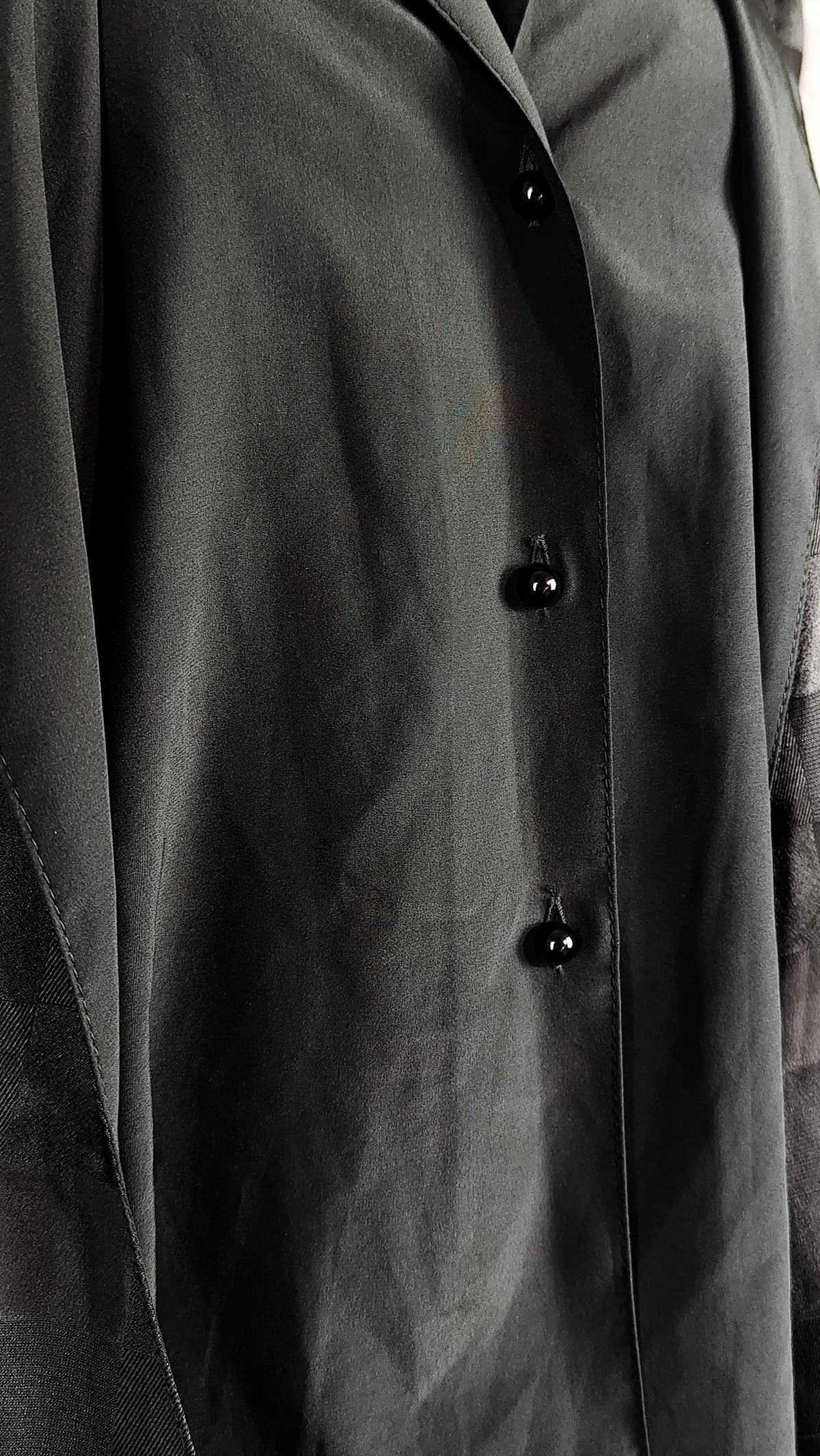 Close-up of pearl-shaped buttons of a black patterned sheer blouse from the 90's with a checkered design, for sale at Faceless Queen store. 