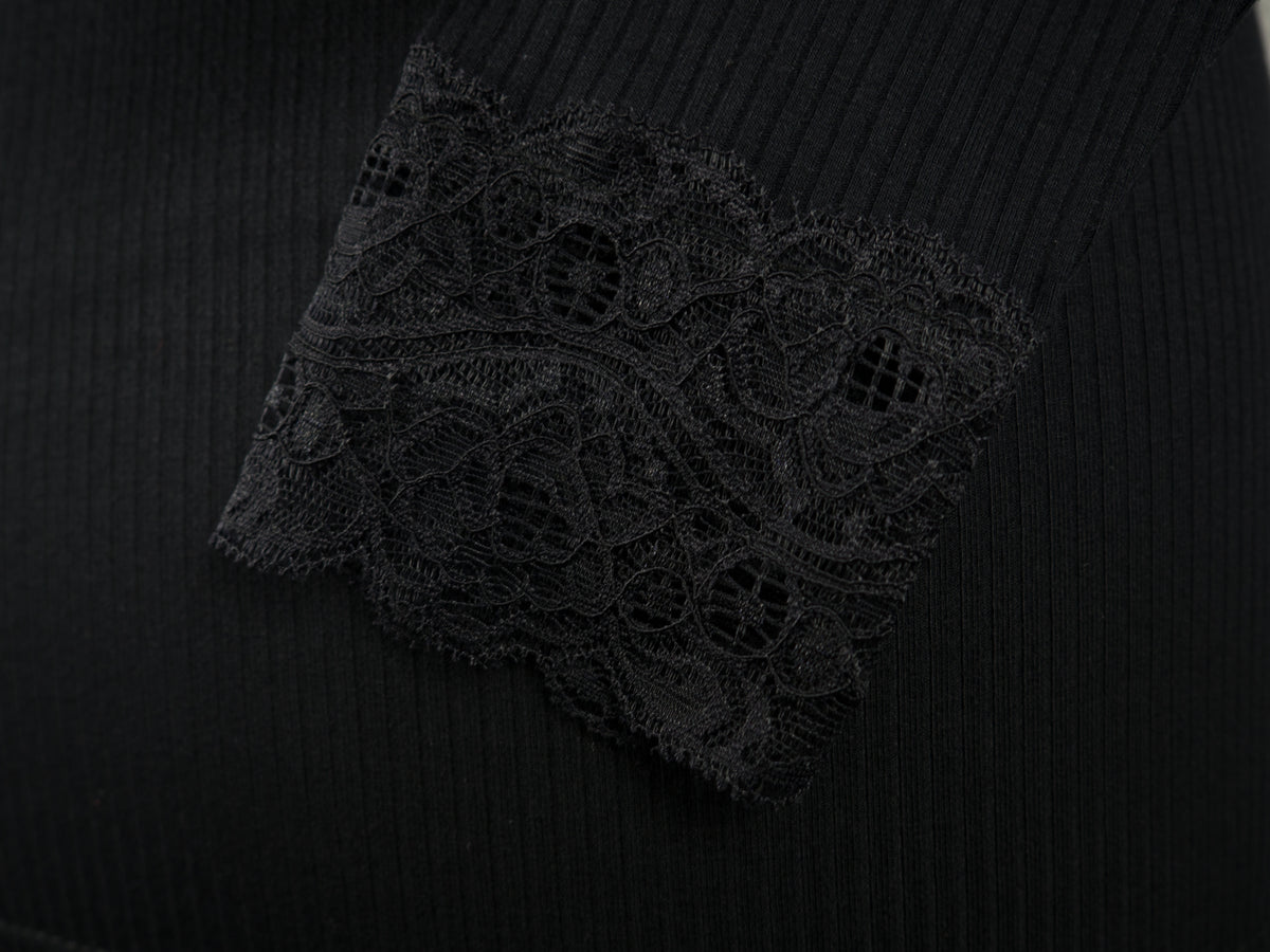 Close-up of a laced cuff from a long-sleeve ribbed knit black top.