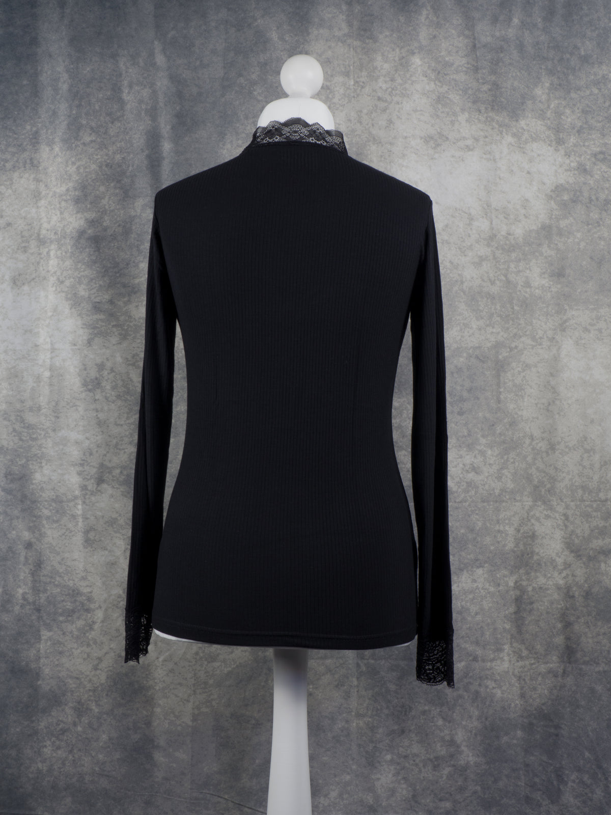 Back view of a black Long sleeve top with lace collar and lace cuffs. Gothic aesthetic.