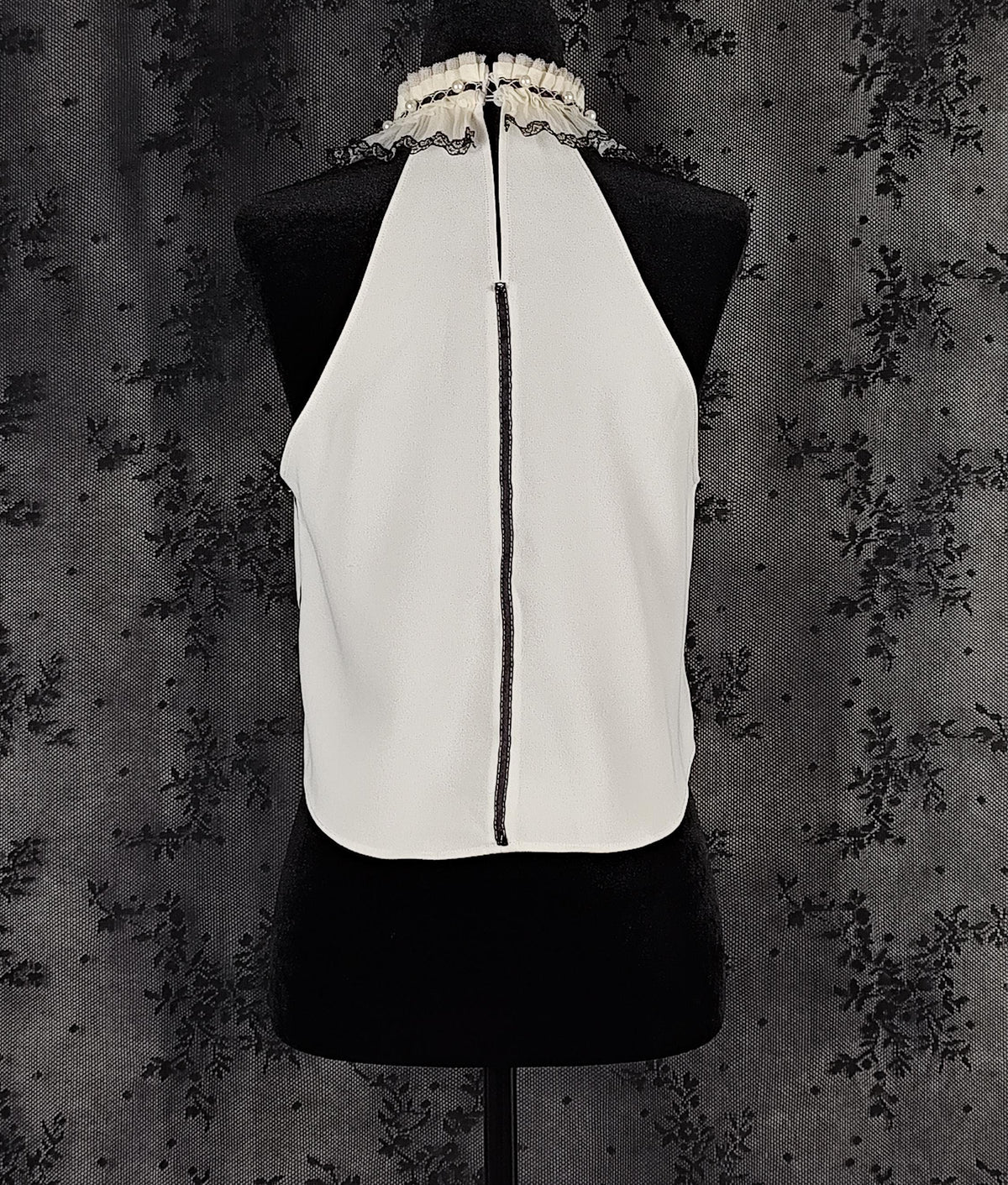 Back view of a Zara white sleeveless blouse transformed by Faceless Queen with black lace trim and a ruffled high neck.
