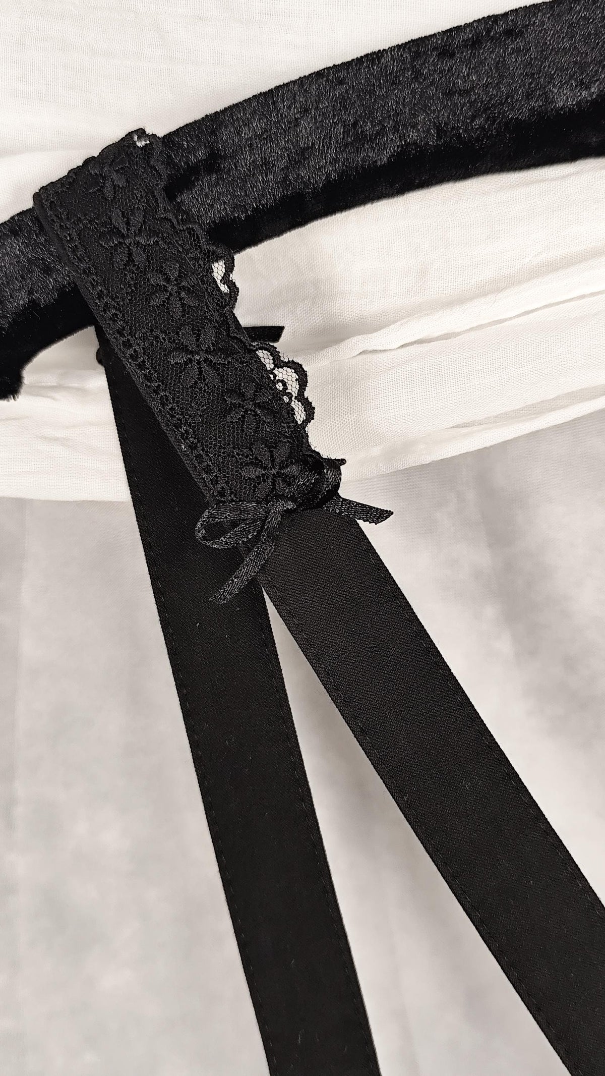 Close-up of strap with lace and satin bow. 