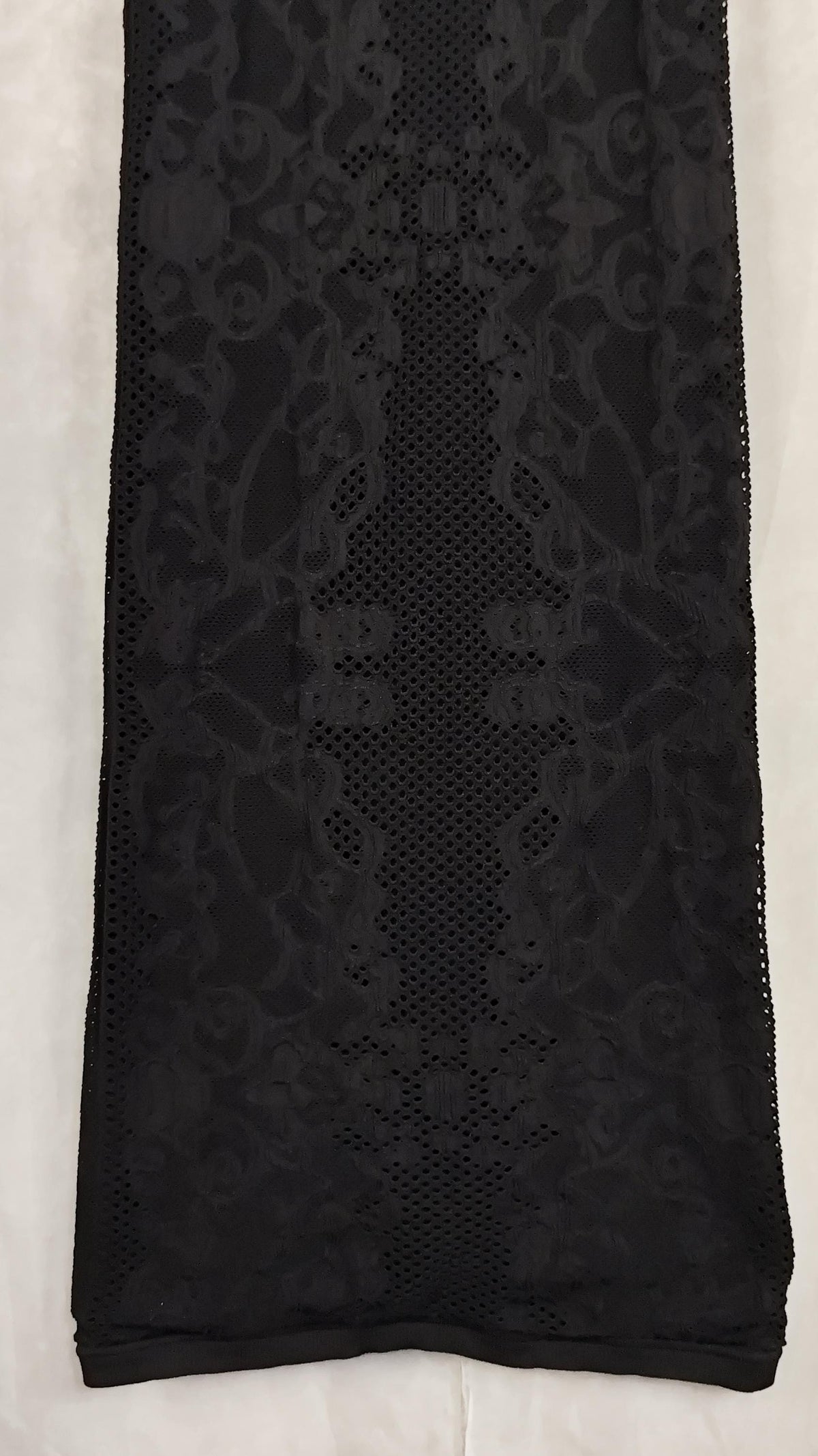 Black sheer lace dress with a floral pattern and openwork mesh, laid flat on a white background.