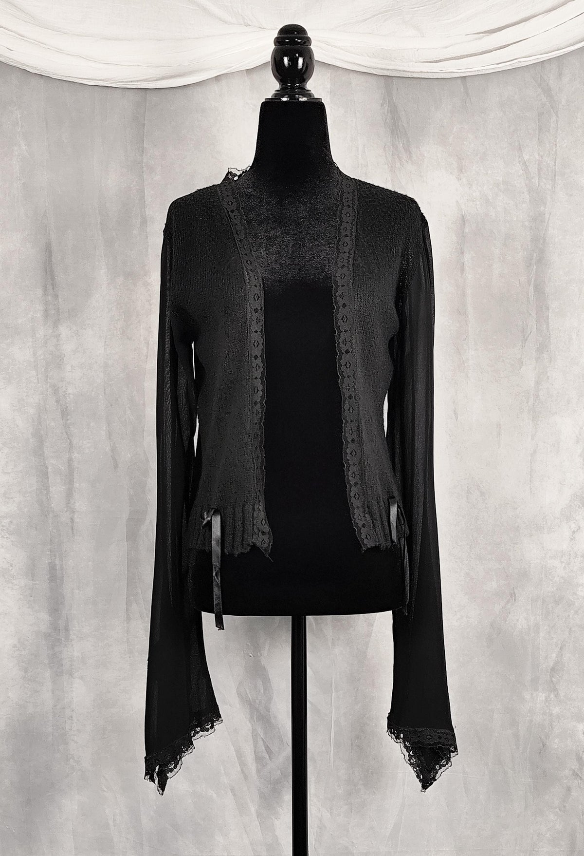 Front view of a black long-sleeve lace-trim cardigan for sale by Faceless Queen. 