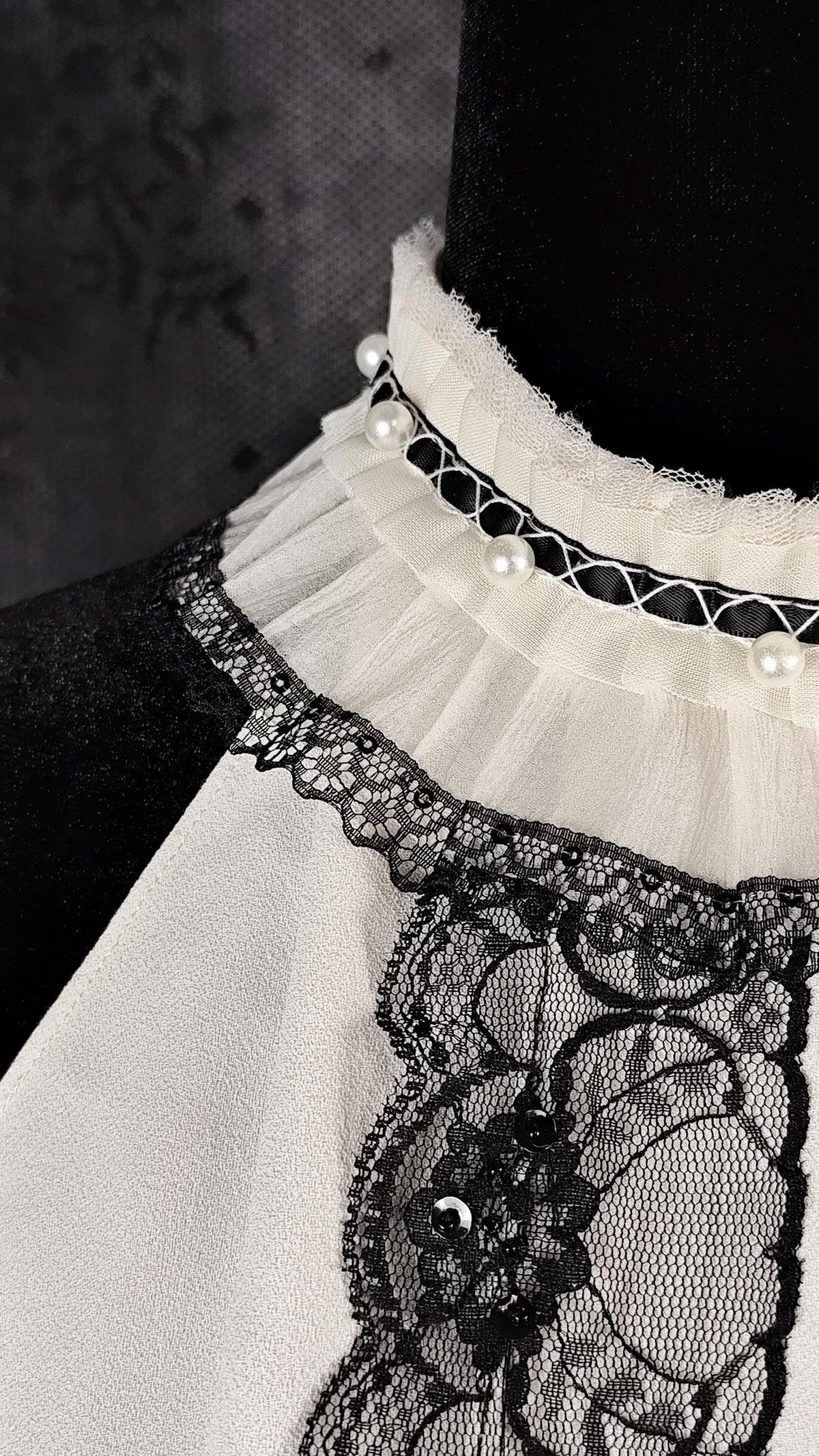 Close-up of a ruffled collar with satin, pearls and lace placed on a Zara top  by Faceless Queen.