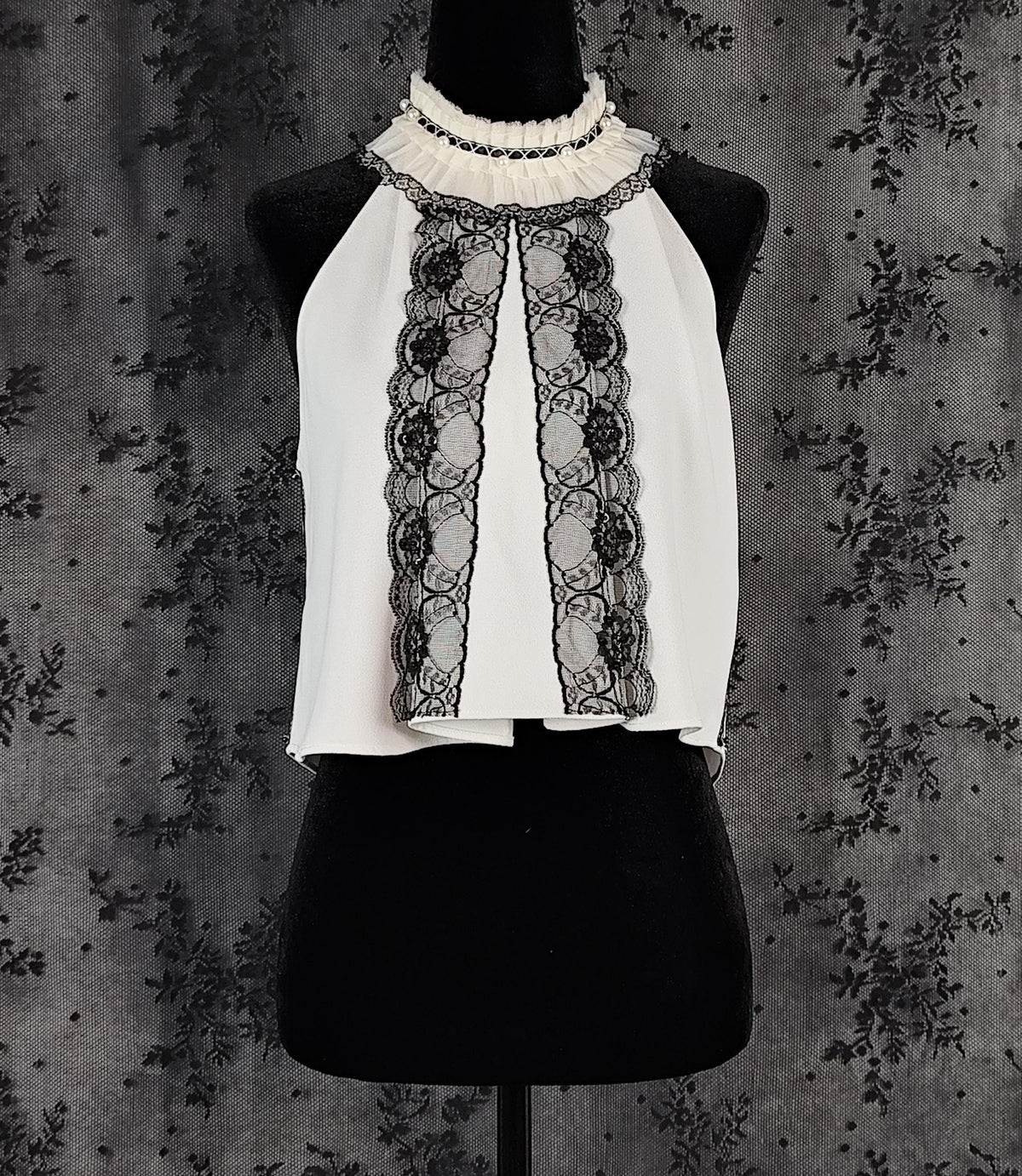 Front view of a Zara white sleeveless blouse transformed by Faceless Queen with black lace trim and a ruffled high neck.