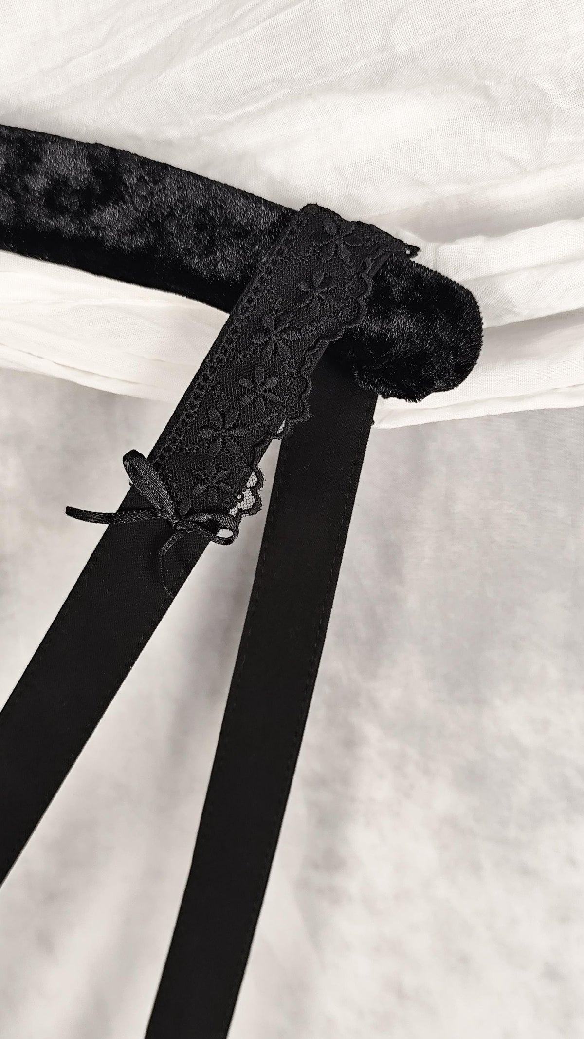 Close-up of strap with lace and satin bow. 