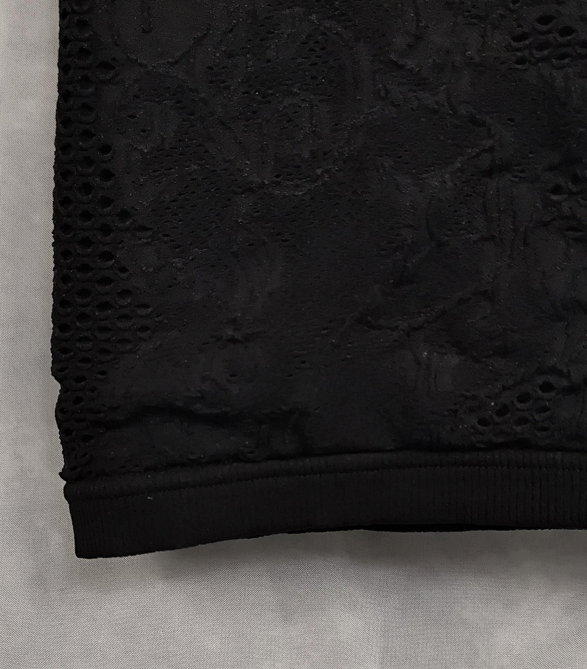 Close-up of pattern from a black mesh lace dress.
