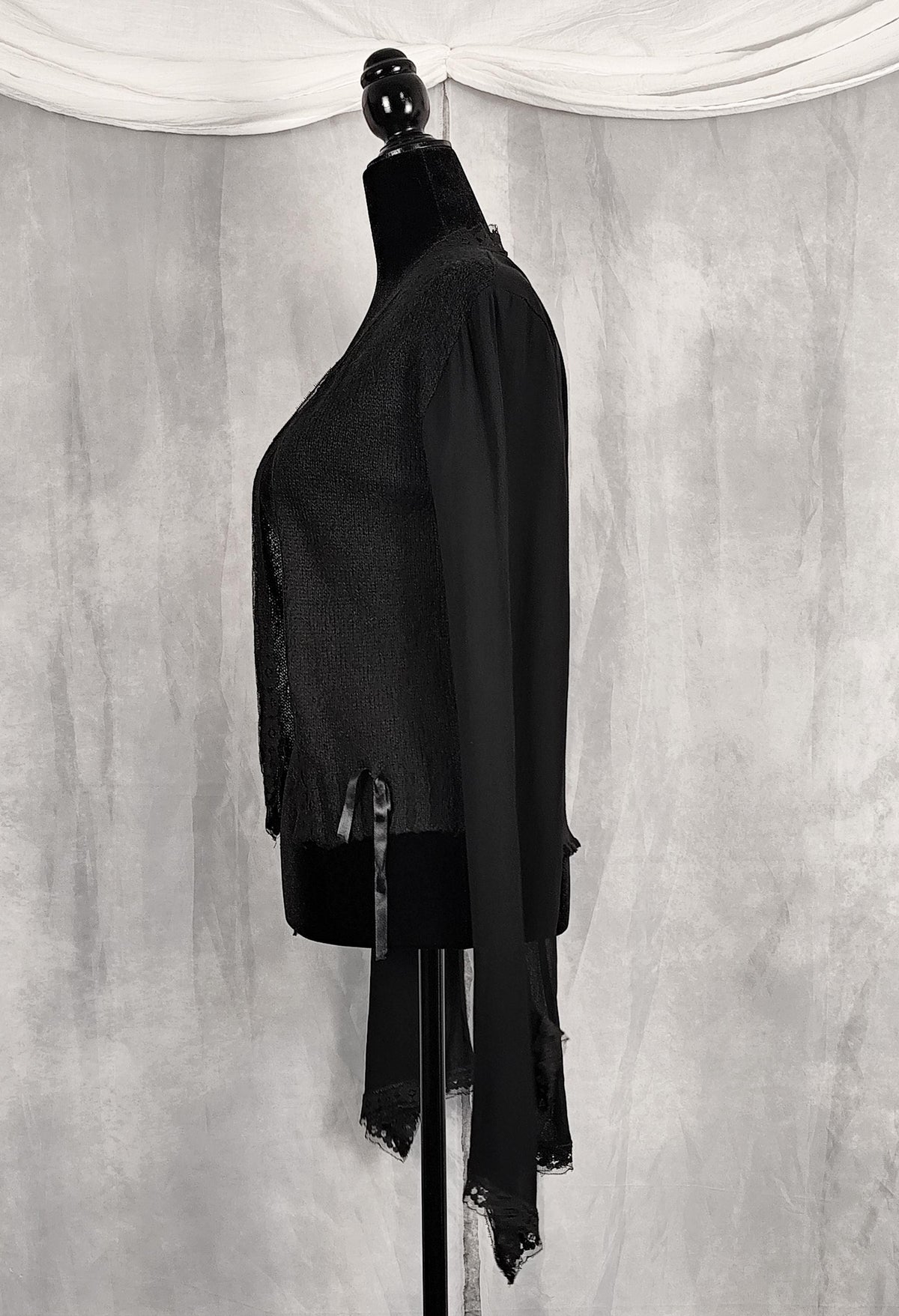 Side view of a black long-sleeve lace-trim cardigan for sale by Faceless Queen. 
